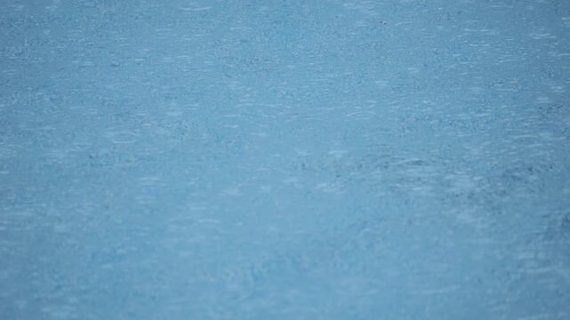 Blue pool surface dominates frame, ripples dance under bright sun, reflections shimmer across cool tones. White lattice edge peeks from corner, tile border adds geometric texture