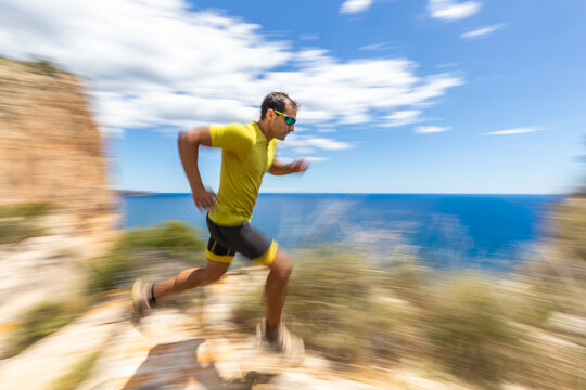 Trail running along seaside cliffs under blue sky