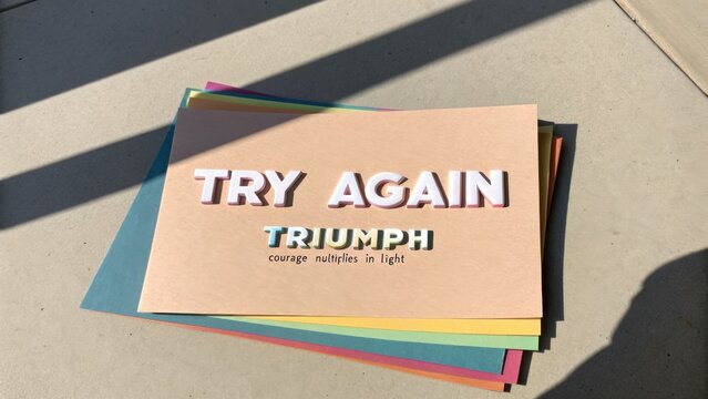 Inspirational message against sunlight on colorful paper sheets focused on growth, perseverance, and positive mindset for self-improvement