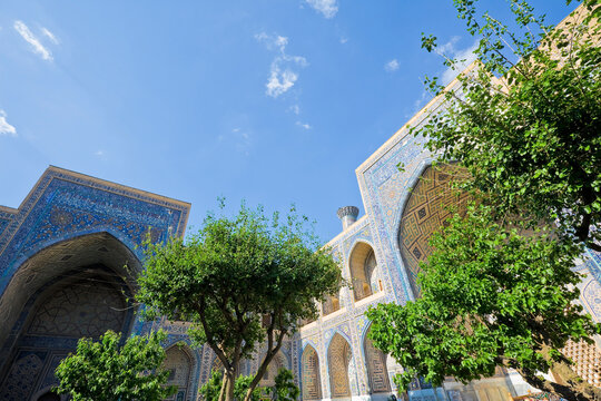 UZBEKISTAN - SAMARKAND - ULUGH BEG MADRASA COURTYARD WITH ISLAMIC ARCHITECTURE, MOSAIC TILES AND ARABIC CALLIGRAPHY AT HISTORIC REGISTAN SQUARE IN UZBEKISTAN