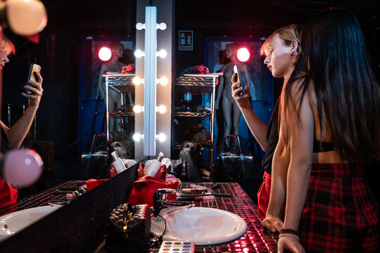 Actors taking a mirror selfie while getting ready backstage