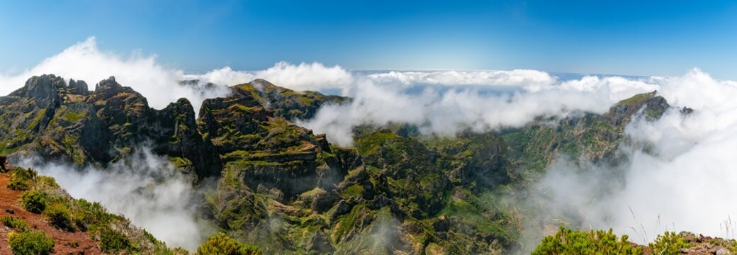 Summit view over green ridges above the clouds