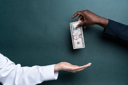 Multiethnic hands exchanging cash on green background