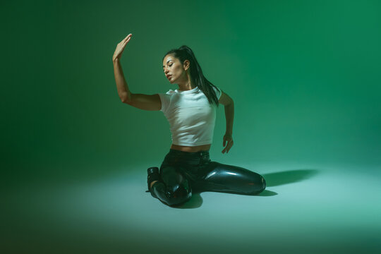 Woman dancer posing in studio with green lighting