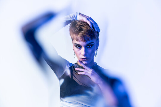 Young woman fashion model posing in studio with blue light