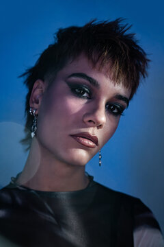 Studio portrait of young woman fashion model in blue light