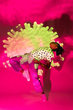 Afro woman dancer in neon studio with abstract light