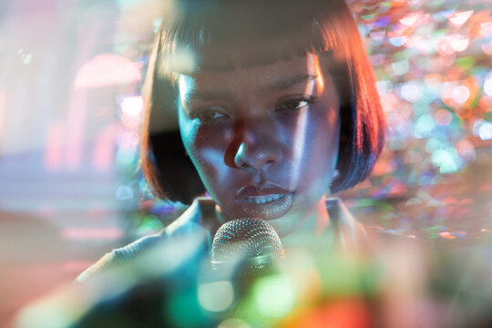 Young Latin woman singer performing with microphone, close-up