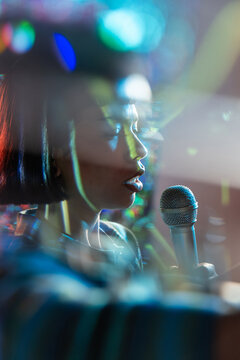 Young Latin woman singer performing with microphone on stage