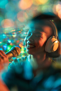 Young Latin woman singer recording vocal with headphone