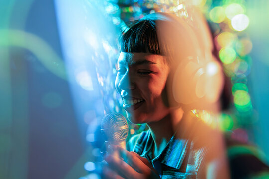 Young Latin woman singer performing in neon light