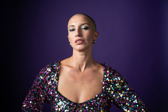 Middle aged shaved head fashion model in sequin dress