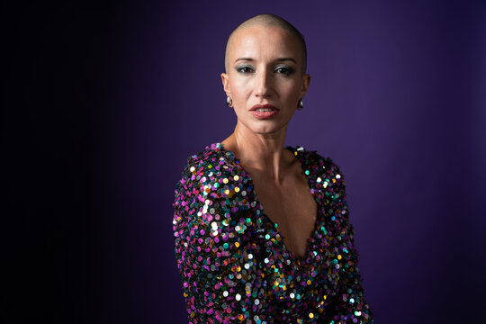 Middle aged shaved head fashion woman in sequin dress