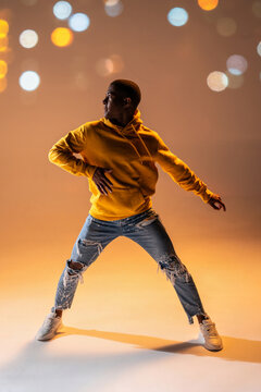 Urban dance pose of a black man in yellow hoodie