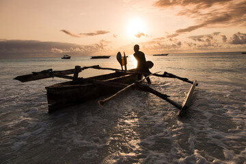 Afrykańscy rybacy ze swoimi drewnianymi katamaranami na plażach Zanzibaru w świetle wschodzącego słońca © kubikactive