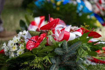 Wieniec kwiatów i dwie świece biało czerwone. © FotoDax