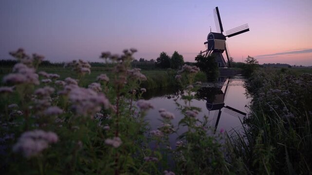 Broekmolen Windmill at Twilight in the Netherlands, Historic Dutch Polder Landscape with Vibrant Pastel Sunset Reflection in a Calm Canal.