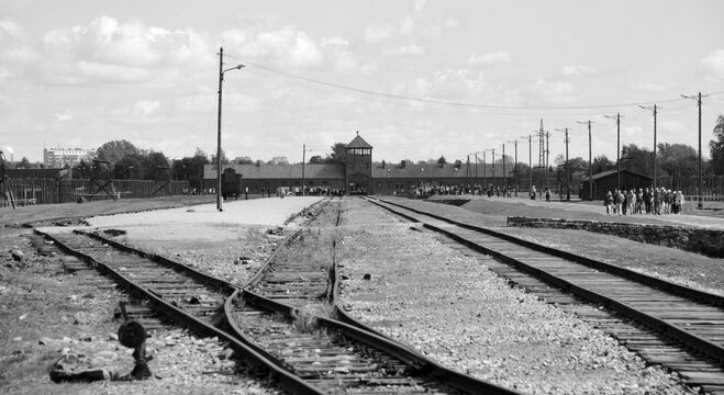 Main gate to nazi concentration camp of Auschwitz Birkenau Poland with train rail. Here were exterminated 1.5 million people at the second world war. Auschwitz II-Birkenau Gate (The Gate of Death)