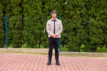 Fototapeta premium Young man stands calmly on a brick path