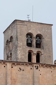 Romanesque bell tower with bells and weathervane