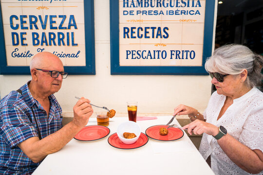 Senior couple enjoying tapas and beer at Spanish bar