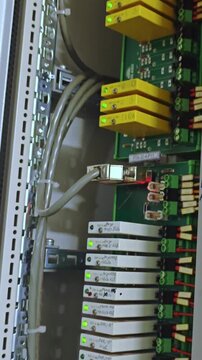 Colorful electronic setup. Vivid array of tech components. Cluster of bright relays and modules in server environment. Vertical arrangement of illuminated relays and modules within data center