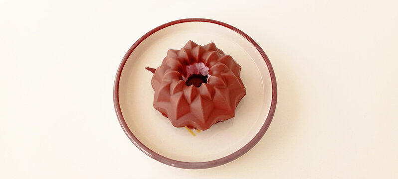 Mini vanilla New York cheesecakes baked in muffin tins are served with a chocolate cheesecake frosting.