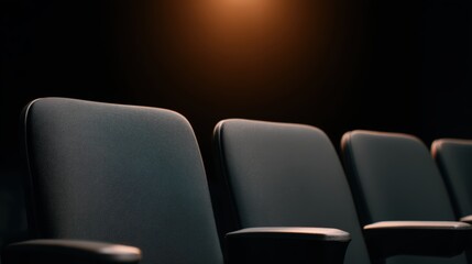 Fototapeta premium A row of empty, dark theater or cinema seats under soft warm lighting, highlighting texture and shadows in a quiet, dim environment.