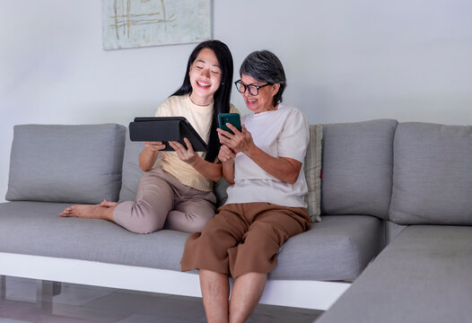 Mother and daughter bonding over technology at home