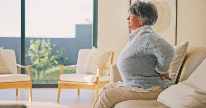 Senior, woman and back pain on sofa, injury or fibromyalgia with osteoporosis in living room. Discomfort, retirement or person with sore spine at home, arthritis or muscle tension with health problem