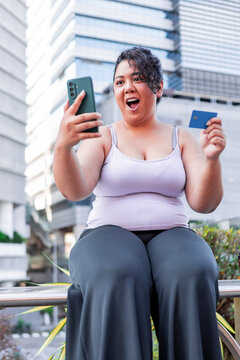 Asian woman shopping online with smartphone and credit card