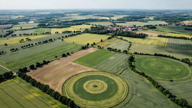 Aerial view of agricultural fields with circular crop patterns and rural village