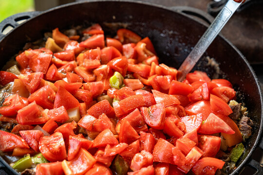 Fresh vegetable stew cooking outdoors in a cast iron pot