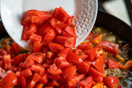 Fresh vegetables being added to hearty stew preparation