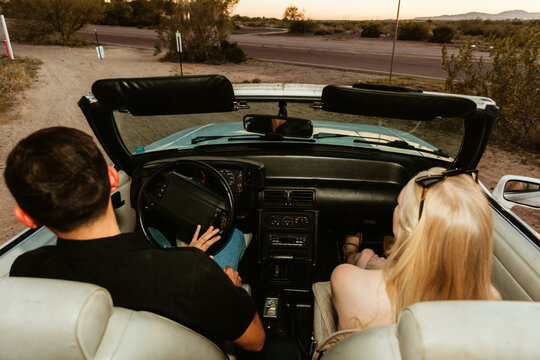 young man and woman in convertible