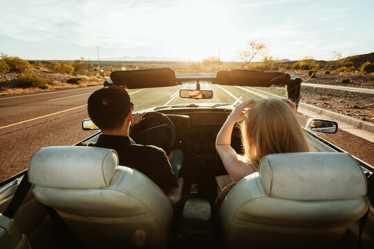 young couple driving in convertible