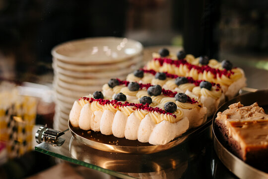 Assorted berry cream pastries displayed in a cafe case