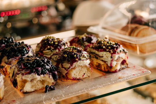 Pastries with berry glaze and cream in bakery display case