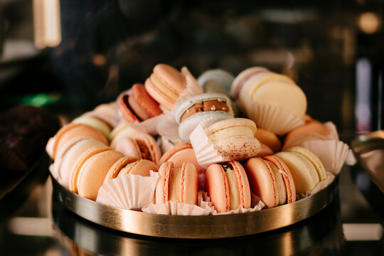 Assorted French macaron cookies piled on a tray closeup