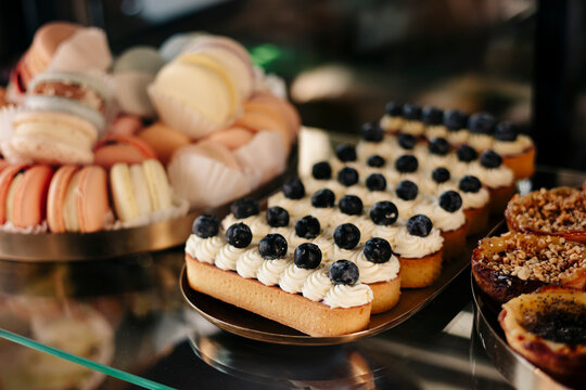 Assorted pastry display with macarons and blueberry eclairs