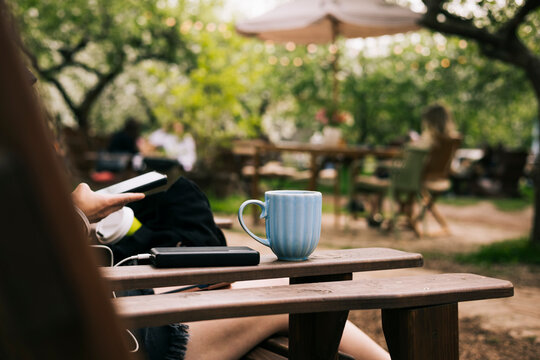 Rustic spring garden cafe table with coffee and smartphone