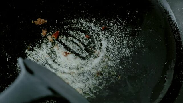 Close-Up of Worn Nonstick Teflon Frying Pan Being Scrubbed with Kitchen Utensil, Illustrating Cookware Safety and Potential Health Risks, 4K 60fps