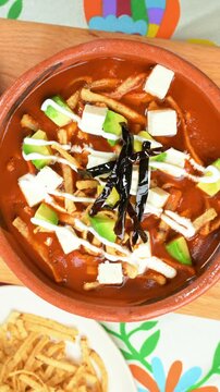 Mexican soup. Sopa de tortilla, traditional Mexican dish with crispy tortilla strips and pasilla chili