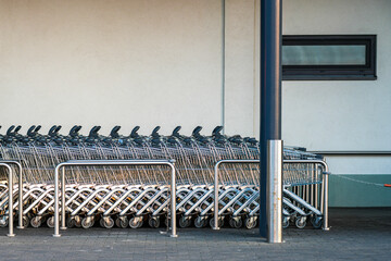 Shopping Carts Parked Outside Supermarket Entrance Ready for Customers and Everyday Retail Shopping Use © Zigmunds