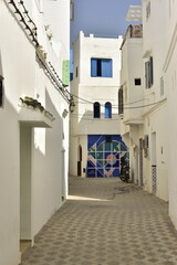 Fototapeta premium Ruelle typique entre les mur blancs au centre historique d'Assilah au Maroc 
