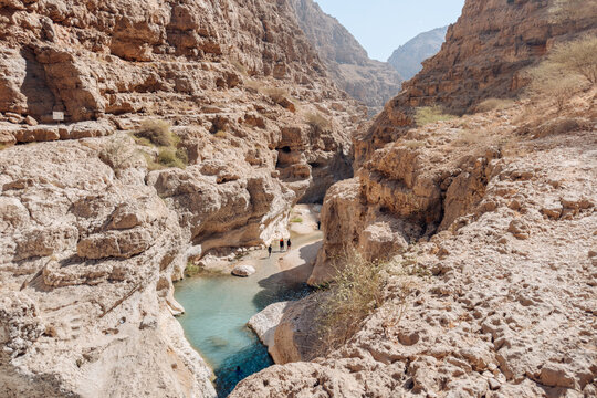 Famous tourism attraction in Oman featuring turquoise canyon water, rocky gorge and natural swimming pools at Wadi Shab