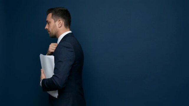 Businessman in suit adjusting tie and holding papers. Professional executive preparing for meeting. Corporate management, work task and responsibility office concept.