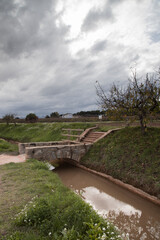 Fototapeta premium Stone bridge spanning canal with path leading up