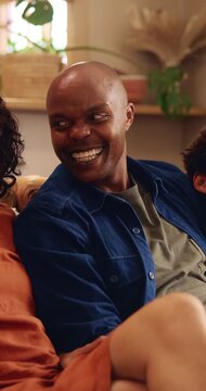 Family, happy man and relax on sofa with love, comfort and watching TV on weekend in home. African parents, children and smile in living room for comedy, relationship development and laugh on couch