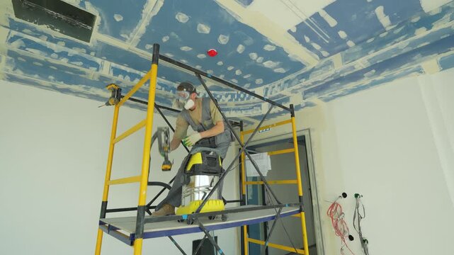 Worker in protective gear performing finishing work on scaffolding